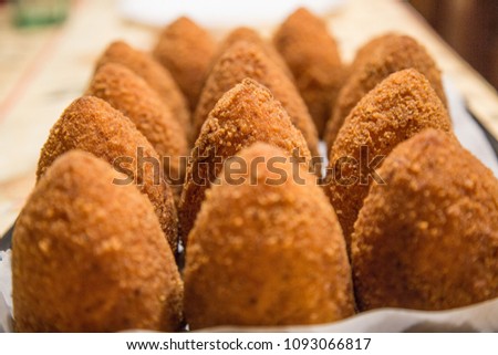 Sicilian "Arancino" a typical street food from Sicily in Italy. Delicious rice balls made with fried rice.
 Royalty-Free Stock Photo #1093066817
