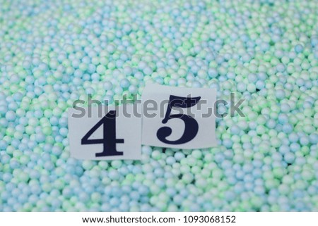 The number 45 of the piece of paper in a pile of small spheres