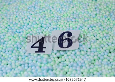 The number 46 of the piece of paper in a pile of small spheres