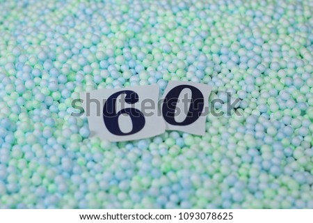 The number 60 of the piece of paper in a pile of small spheres