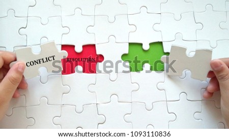 Hand embed missing a piece of puzzle into place, red space with word CONFLICT RESOLUTION. Business and financial concept.

