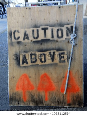 Caution Above Streets Sign on sidewalk