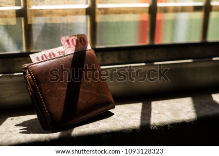 Leather wallet beside window.Money.Top view. Royalty-Free Stock Photo #1093128323