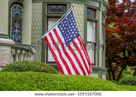 Flag on historic Victorian home Royalty-Free Stock Photo #1093187000