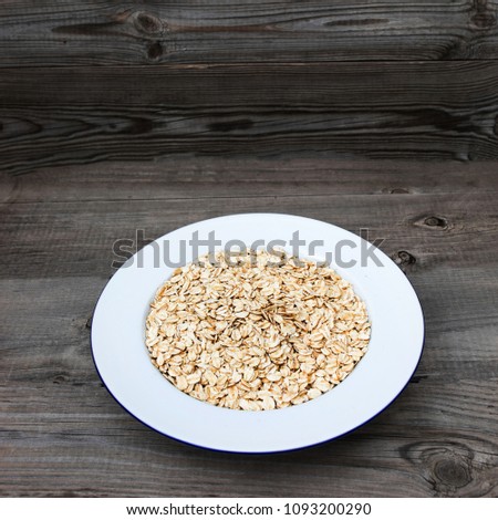 Oatmeal, rolled oats on rustic white wooden background.  