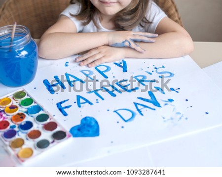 Child making homemade greeting card. Painted hand. A little girl paints a heart on a homemade greeting card as a gift for Father Day. Finger paint. Traditional play concept. Art and craft concept