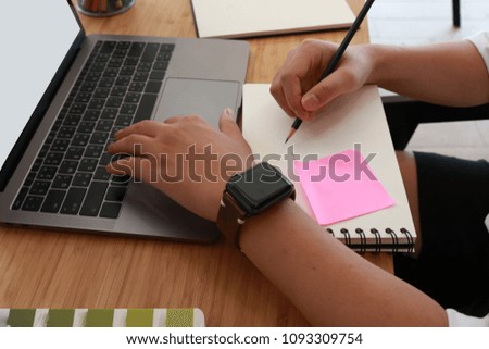 Businessman at work. Close up of man working on laptop while sitting at the white wooden desk in modern office.