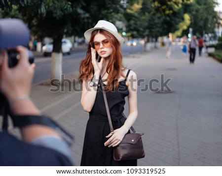Models in a hat and in a black dress on the street.