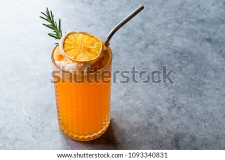 Dried Orange Cocktail with Foam, Rosemary and Metal Straw. Royalty-Free Stock Photo #1093340831