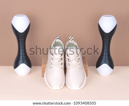Shot of golden sneakers on beige background. Stylish healthy lifestyle concept.