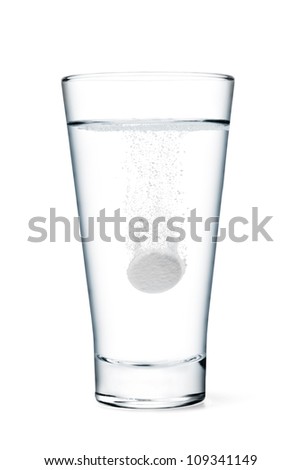 Fizzy tablet in glass of water isolated on white
