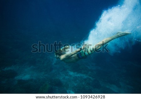 underwater pic of young man diving in ocean alone