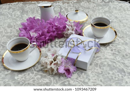 Coffee with a gift and flowers. 