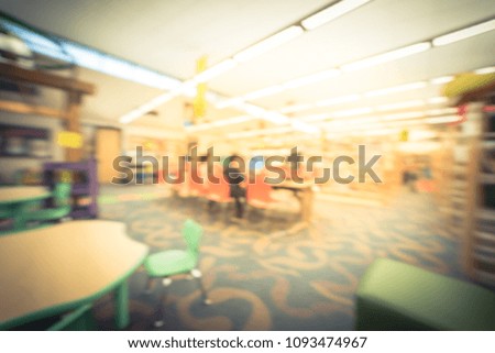 Vintage blurred computer station at public library in Texas, USA. Abstract library interior with unidentified student are searching, reading information, playing game