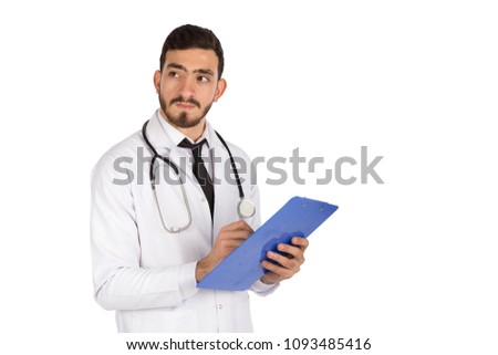 Side shot of a handsome doctor wearing his coat and stethoscope holding a pen and a paper, writing a description and he is looking away, isolated on white background