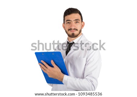 Handsome doctor wearing his coat and stethoscope holding a pen and a paper, writing a description, on his face big smile, isolated on white background