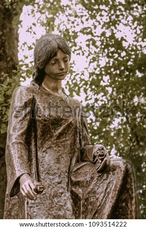bronze sculpture of sad woman. beautiful tombstone angel statue in old cemetery. background for condolence, mourning cards or obituary. 