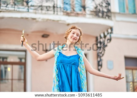 Beautiful girl artist on the street in blue dress 