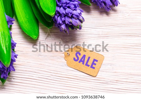 Sale tag and Hyacinth flowers on wood backgroubd