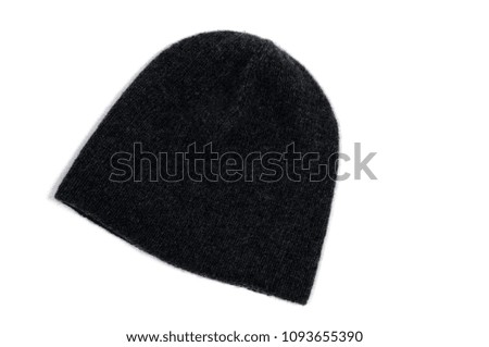 Dark gray knitted hat, handmade on a white background. View from above.
