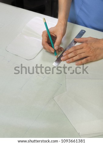 A woman working on patterns in a small family tailor