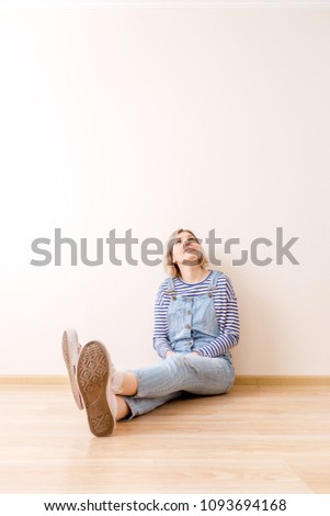Photo of young woman sitting on floor