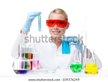 Female doctor in spectacles does some experiments with blue liquid, isolated on white
