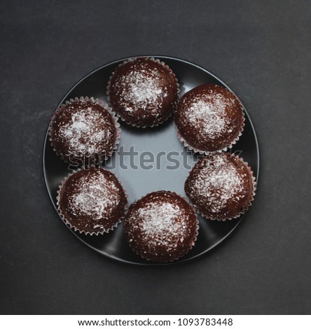 Homebaked Chocolate Muffins in black Round Plate. Dark Background. Square image.