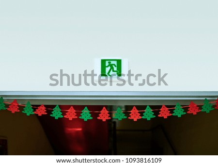 An emergency exit with a Christmas tree hanging on it
