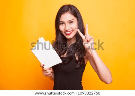 Young Asian woman with a book have an idea on yellow background