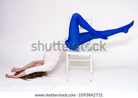 I love yoga. Portrait of a beautiful woman on a white background doing exercises on a chair.