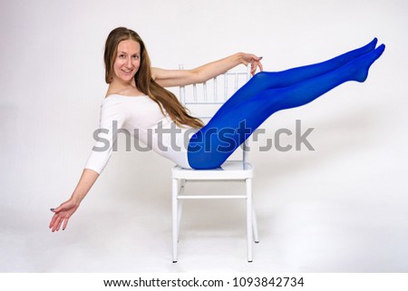 I love yoga. Portrait of a beautiful woman on a white background doing exercises on a chair.