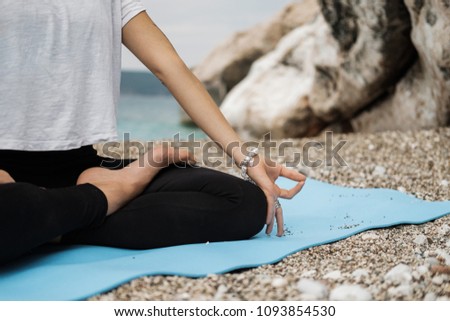 Close up Hand of Woman Doing an Outdoor Lotus Yoga Position and meditation on the beach by the sea