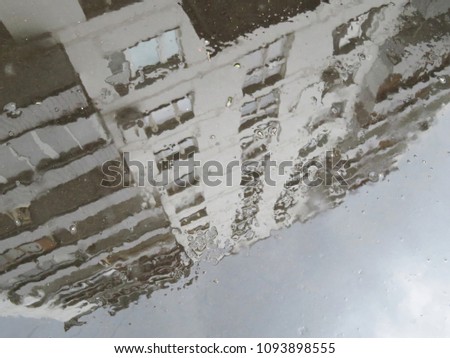 Rainy weather. Reflection of the building in a puddle after rain