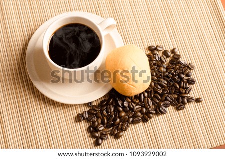 Hot coffee and coffee bean on wooden background.