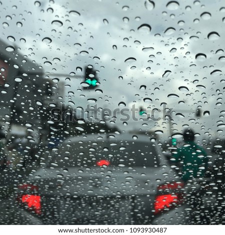 Rain drops on the windshield while the car is on the road