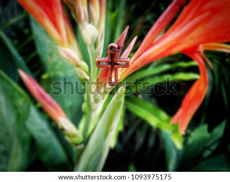 Christian cross on blurred colorful flower background, image with selective focus and vintage theme process