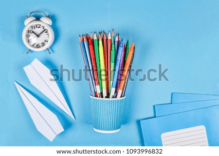 Back to school concept. Creative, minimalistic style. School and office supplies on blue background. Flat lay with copy space.