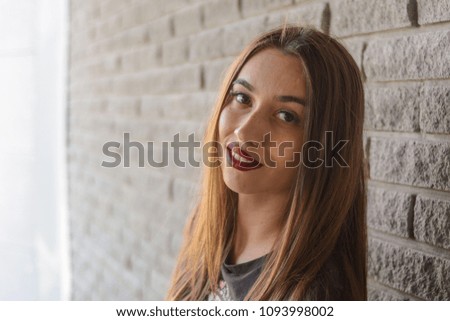 Fashionable beautiful woman in a summer day against a gray wall background Royalty-Free Stock Photo #1093998002