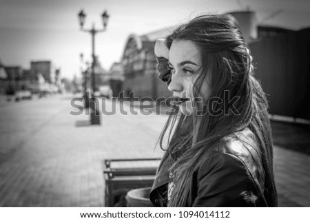 portrait of a beautiful girl in a summer day sitting on a park bench Royalty-Free Stock Photo #1094014112
