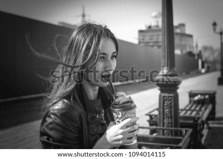 portrait of a beautiful girl in a summer day sitting on a park bench Royalty-Free Stock Photo #1094014115