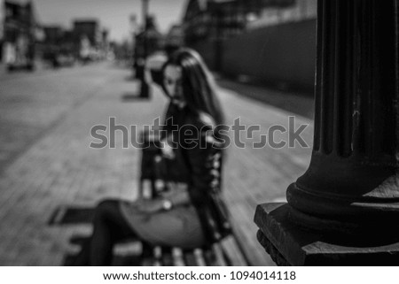 beautiful girl in a summer day sitting on a park bench Royalty-Free Stock Photo #1094014118