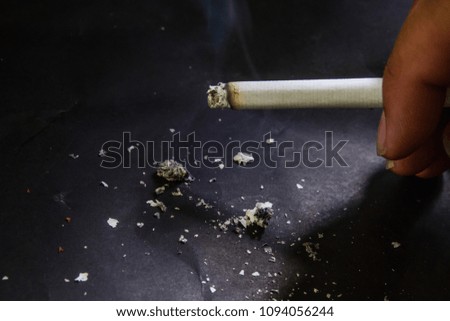 Burning cigarette on black background