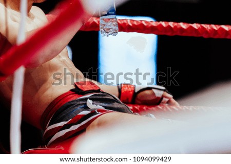 MMA fighter in red corner of ring break between rounds