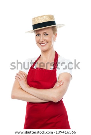 Confident cheerful female cook wearing hat and dressed in white and red uniform