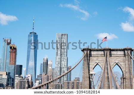 View of lower Manhattan. Wall Street area, and the Brooklyn Bridge with American Flag on top from Brooklyn, New York.  View of lower New York from Brooklyn side.
