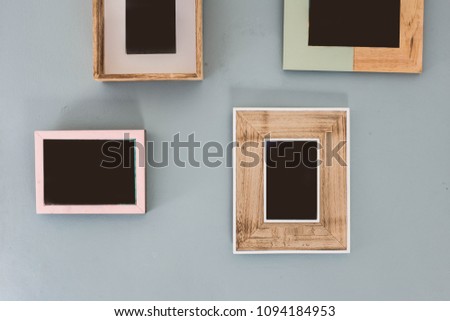 Multiple many blank small picture frames on colorful wall