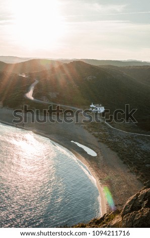 Photography of a sunset against a light on a beach in Menorca, Spain, from the heights.