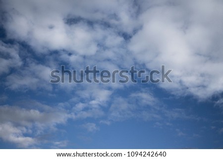 Blue sky background with fluffy cumulus clouds