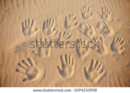 lots of hand prints on the sand.